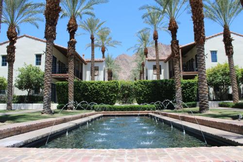 a pool in front of a house with palm trees at Ground Floor 1BR Legacy Villa #A in La Quinta