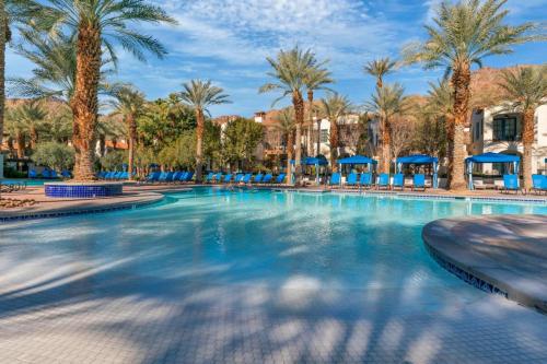 a swimming pool at a resort with palm trees at Ground Floor 1BR Legacy Villa #A in La Quinta