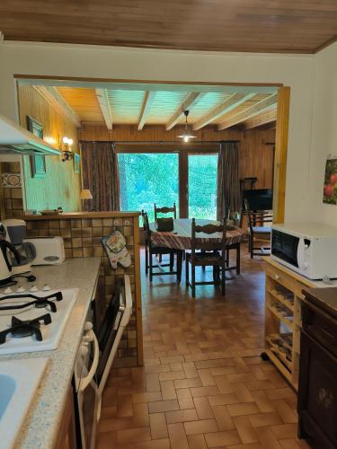 Il comprend une cuisine équipée d'une cuisinière et une salle à manger avec une table. dans l'établissement Chalet vue montagne nature à Abriès Queyras, à Abriès