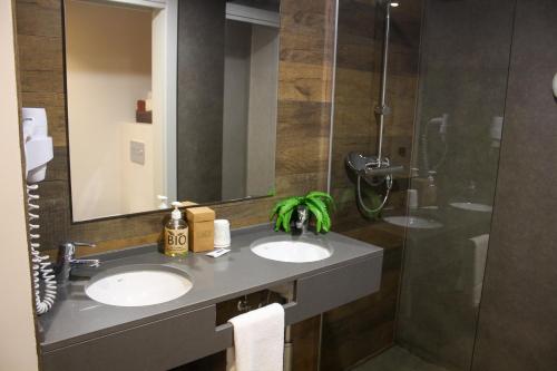 a bathroom with two sinks and a shower at Hotel Vall d´Aneu in Esterri d'Àneu
