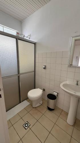 a bathroom with a toilet and a sink at Hotel Colonial in Cajati