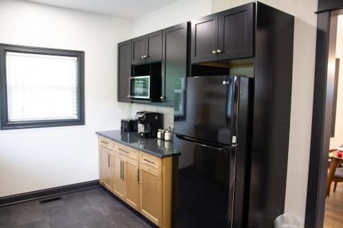 a kitchen with black cabinets and a black refrigerator at 5 Minutes to the Falls-Luxury Home 3BR 2 Bath - USA Side in Niagara Falls