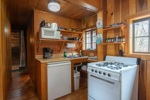 a kitchen with a stove and a white stove top oven at Moore House Inn & Cabins in Marlinton