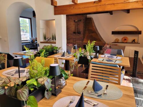 a dining room with tables and chairs with plants at Landhaus am Kurpark in Baden