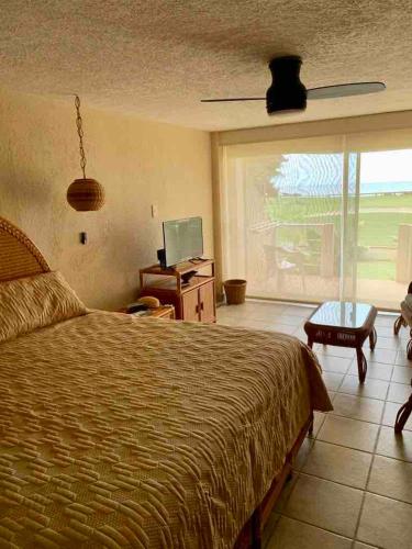 a bedroom with a bed and a desk and a window at NEW loft on the beach with direct access in Ixtapa
