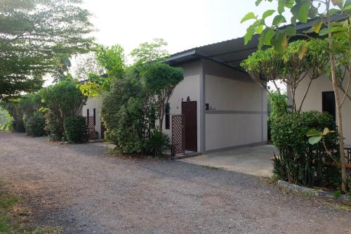 a white garage with a gate and a driveway at เช็คอินรีสอร์ทชัยนาท Check-in resort in Ban Khao Khayai (1)