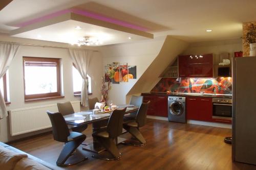 Un comedor con una mesa y una cocina. en Apartmánové byty so saunou a vírivkou, en Predajná