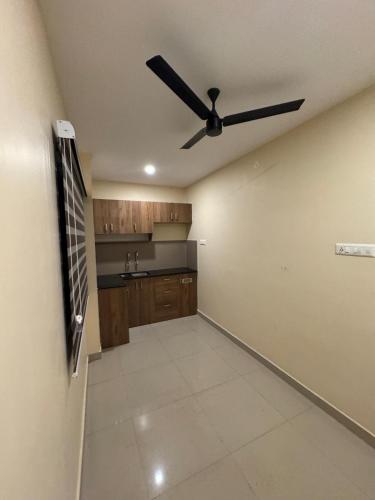 a ceiling fan in a room with a kitchen at Heres Haut Residency in Ernakulam
