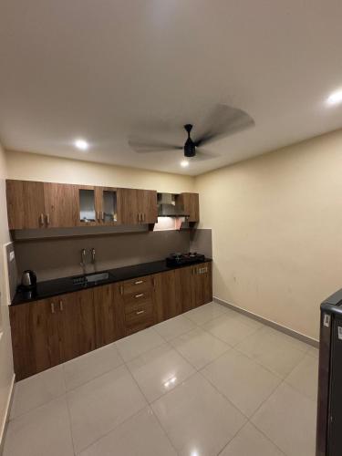 a kitchen with wooden cabinets and a ceiling fan at Heres Haut Residency in Ernakulam