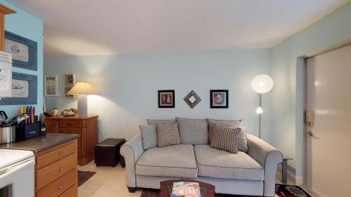 a living room with a couch and a kitchen at Driftwood Landing 14 in Naples