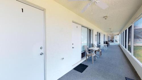 a hallway with chairs and a table and windows at Driftwood Landing 10 in Naples
