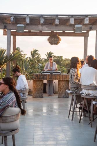 a woman standing at a table in front of a group of people at Suites Panamera in Tulum
