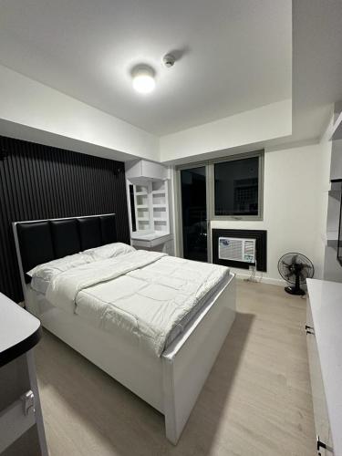 PampangにあるJPC Skyline Condo in Azure pampangaの大きなベッドと暖炉のある寝室