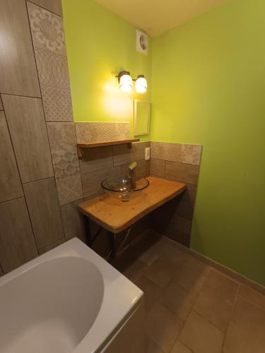 une salle de bain avec un lavabo et une baignoire dans l'établissement Les jardins de Montaland, à Sainte-Catherine-sur-Riverie