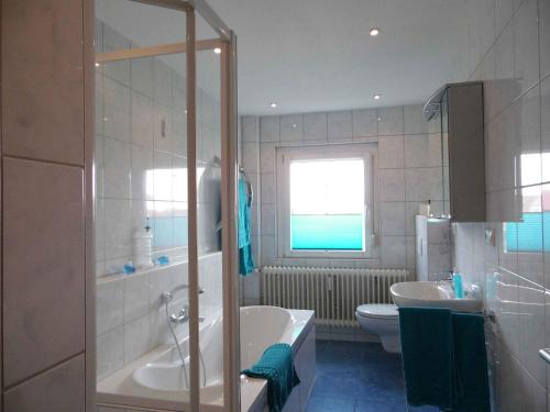 ein Badezimmer mit einer Badewanne, einem Waschbecken und einem WC in der Unterkunft Ferienwohnungen Hog in Ringsheim