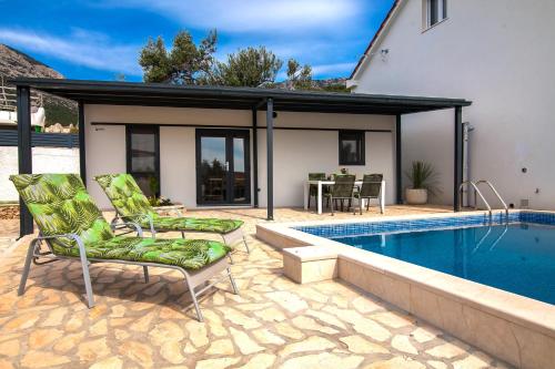 a patio with two chairs and a swimming pool at Oleum - Family Home in Bol