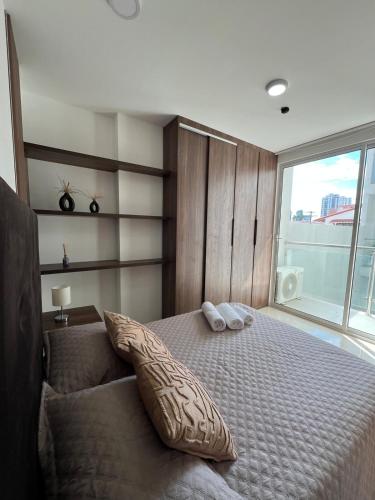 a bedroom with a large bed with a large window at Tu Escapada Chic, a pasos del segundo anillo in Santa Cruz de la Sierra
