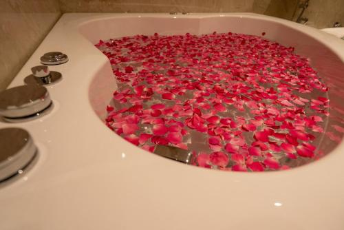 a bath tub filled with red rose petals at Hotel Grand Ajantha in Putuppalli
