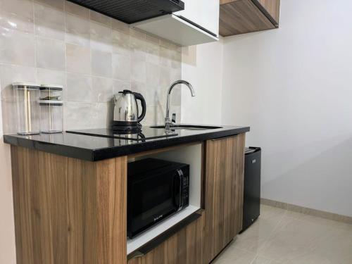 a kitchen with a microwave and a counter top at Tu Escapada Chic, a pasos del segundo anillo in Santa Cruz de la Sierra