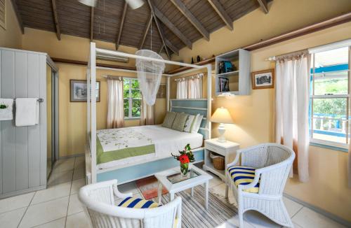 a bedroom with a bed and two chairs at Titi Vacation Homes in Cobbs Cross