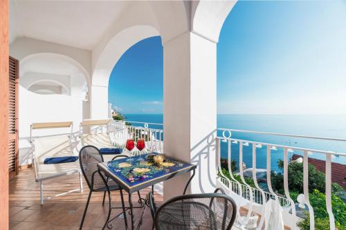 a balcony with a table and chairs and the ocean at Hotel Il Gabbiano in Positano