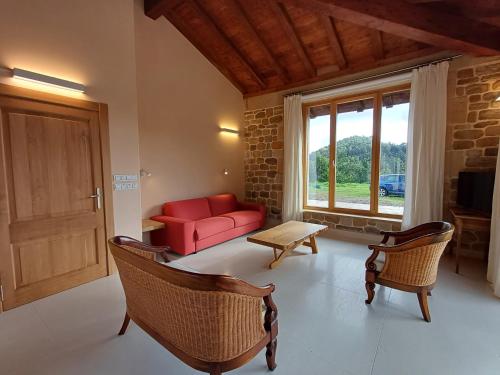 a living room with a red couch and a window at Apartamento en casa de campo Villa Haritza con vistas al mar in Ea