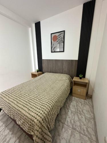 a bedroom with a bed and two night stands at Morada Apart in Tacna