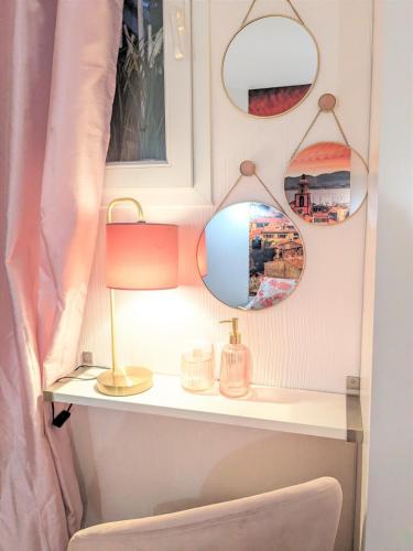 une coiffeuse avec deux miroirs et une lampe dans l'établissement Vue mer et clim Les Magnolias 4006, à Grimaud