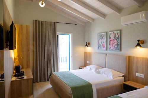 a hotel room with a bed and a window at Sofo Hotel Dhermi in Dhërmi