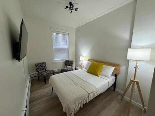 a bedroom with a bed and a television and a chair at Commercial Hotel in Edmonton
