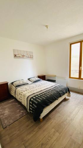 une chambre avec un grand lit et un parquet dans l'établissement Le terminus Appartement 2 chambres, à Nevers