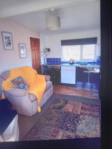 a living room with a couch and a kitchen at 2 bed seaside holiday Chalet in Mablethorpe