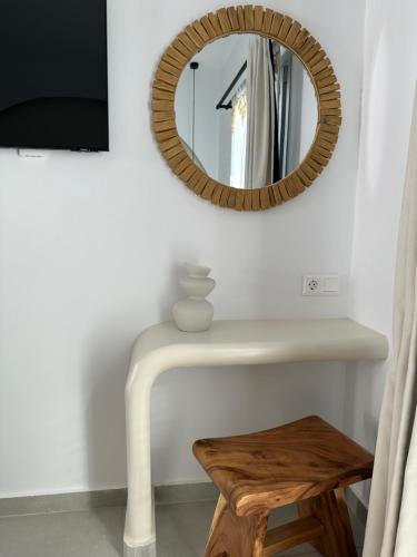 a mirror on a wall with a table and a stool at Marjay Boutique in Parikia