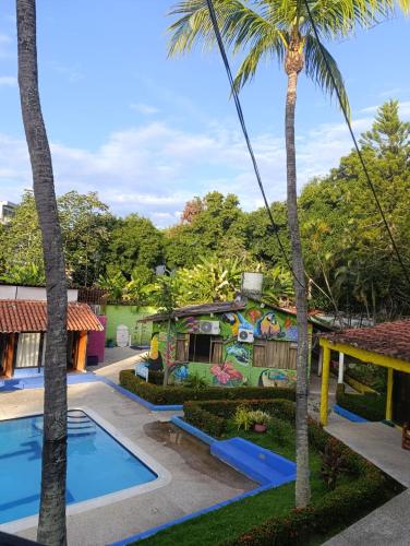 a house with a pool and palm trees at Hotel Palma Paraíso in Melgar