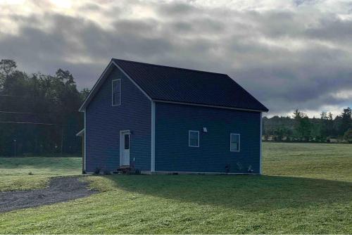 una casa blu in un campo d'erba di Farmhouse cottage close to Smugglers Notch a Cambridge