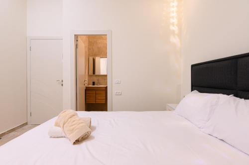 a bedroom with a white bed with a towel on it at וילה לוזאן - Lausanne Villa in Dāliyat el Karmil