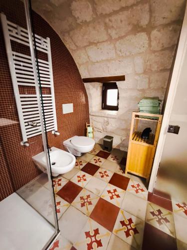 a bathroom with two toilets and a tile floor at Maison Stelas in Bisceglie