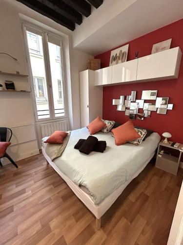 une chambre avec un grand lit aux murs rouges dans l'établissement Large studio - heart of Paris, à Paris