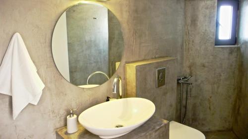 a bathroom with a sink and a mirror at Charming Bright & Airy Loft Studio! in Ierápetra