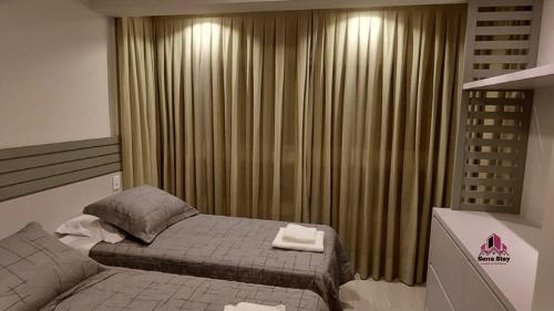 ベント・ゴンサルベスにあるApartamento Luxo em Bento Gonçalvesの窓の前にベッドがある寝室