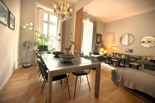 une table à manger et des chaises dans un salon dans l'établissement L'Illustre-Elegant appartement hypercentre-Balcon, à Nantes