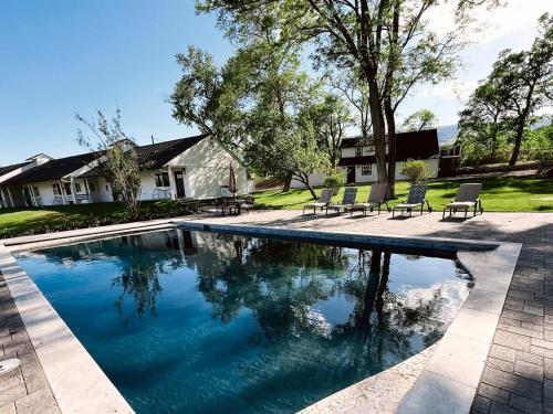 a swimming pool with two chairs and a house at The Ranch House with a Pool Hot Tub and Fire Pit in Reno