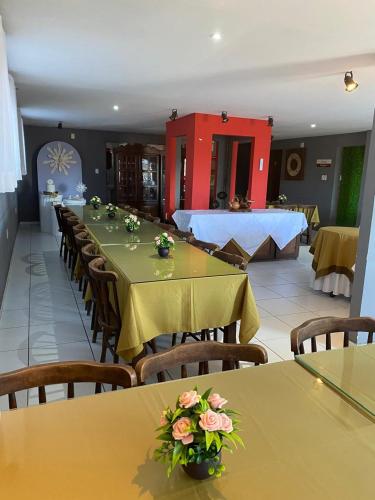 a dining room with tables and chairs with flowers on them at Hotel Rota do Sertão in Serra Talhada