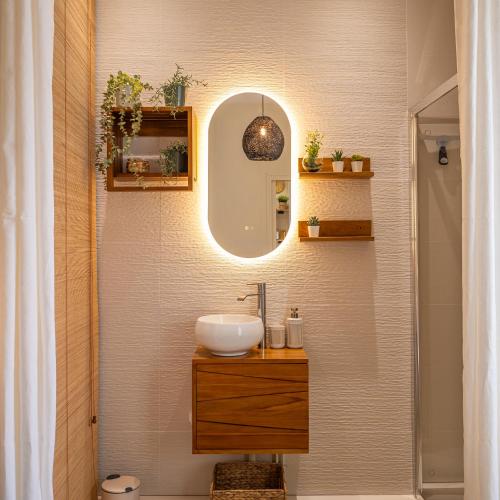 une salle de bain avec un lavabo et un miroir dans l'établissement L'Onyvera, au Mans