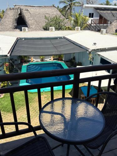 a table and chairs on a balcony with a pool at Hotel Villas Lucciana in El Paredón Buena Vista