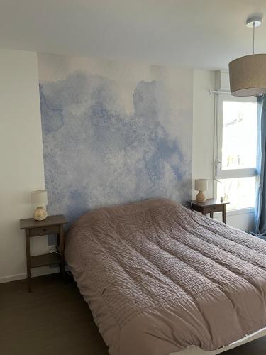 - une chambre avec un grand lit et un mur orné de peinture bleue dans l'établissement Nouveau T3 à 500 m de la plage, à Berck-sur-Mer