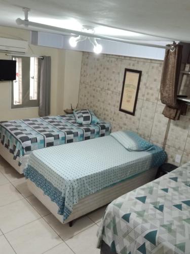 a bedroom with three beds in a room at AP Floripa in Florianópolis
