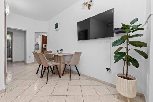 Un comedor con una mesa y una planta en maceta. en New Apartment Lejla, en Šišan