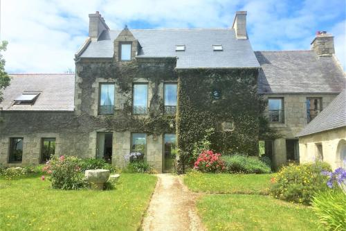 une vieille maison en pierre avec un jardin devant dans l'établissement Manoir du Scluz-Prestigieux domaine vue mer, à La Terre du Pont