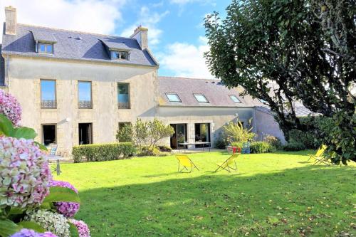 une grande maison avec des chaises dans la cour dans l'établissement Manoir du Scluz-Prestigieux domaine vue mer, à La Terre du Pont